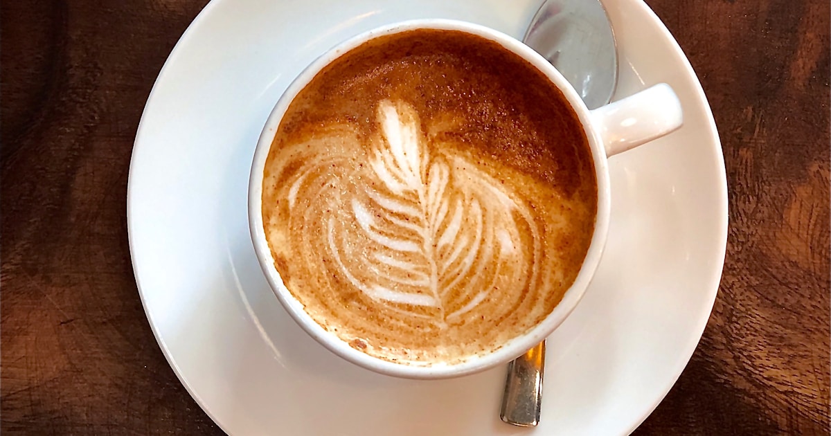 Freshly brewed latte with latte art on a coffee machine counter