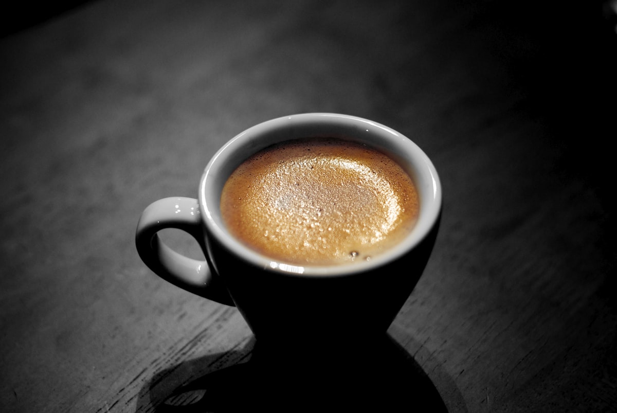 Coffee brewing with a gooseneck kettle and thermometer showing optimal water temperature for pour-over coffee