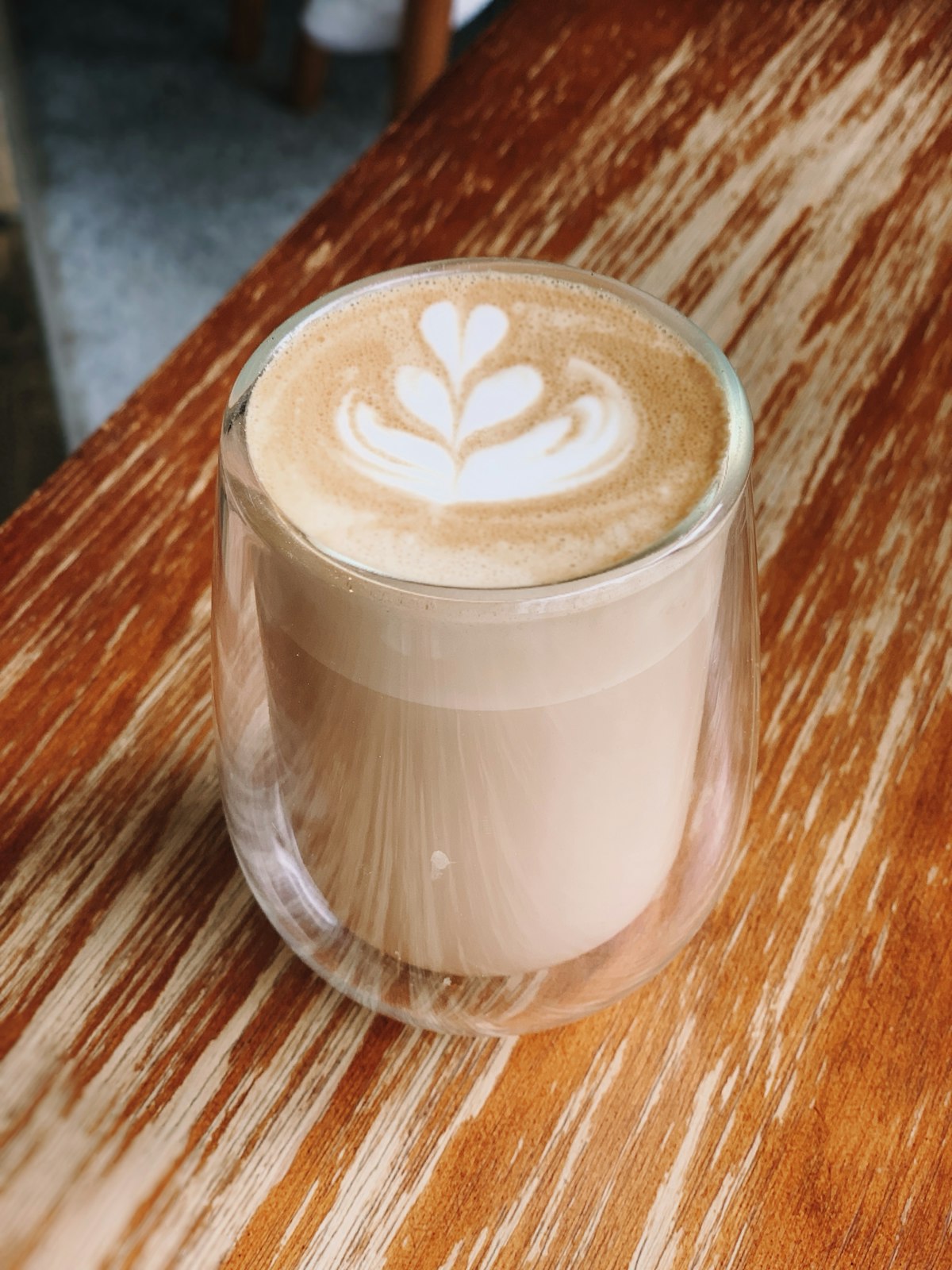 Iced shaken espresso in a tall glass with ice, brown sugar and a layer of milk foam