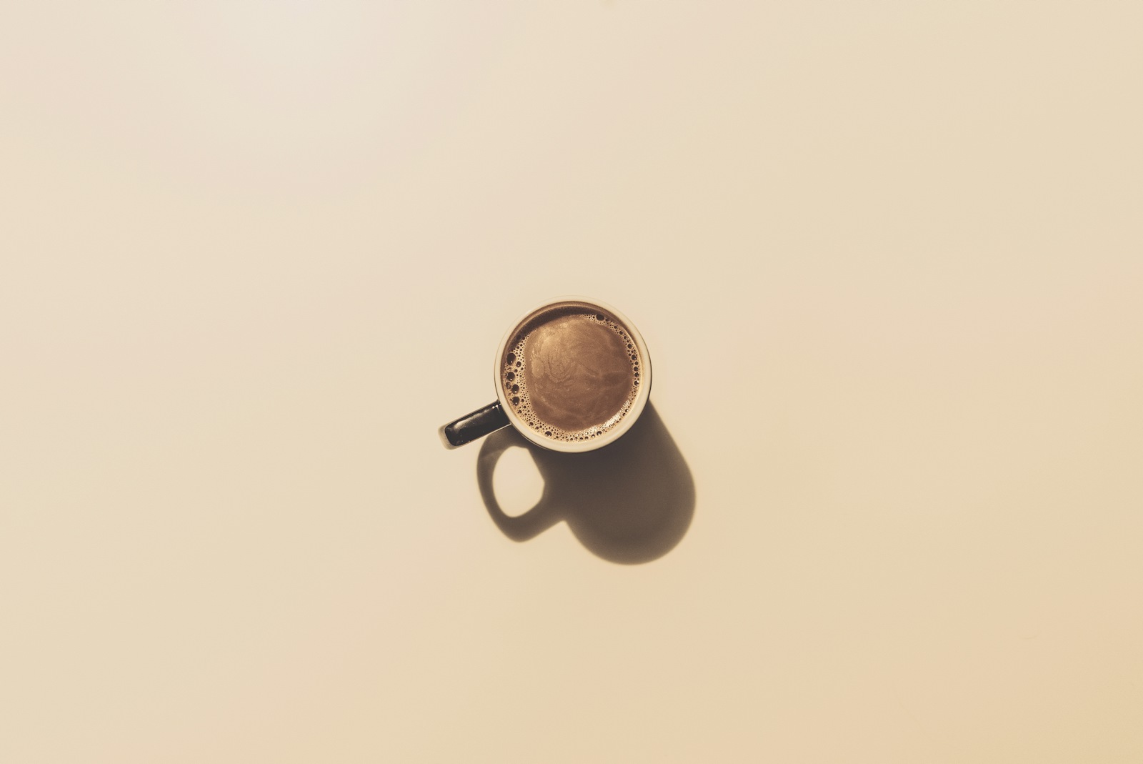 Roasted coffee beans held in a hand, showing the whole beans you need to store properly
